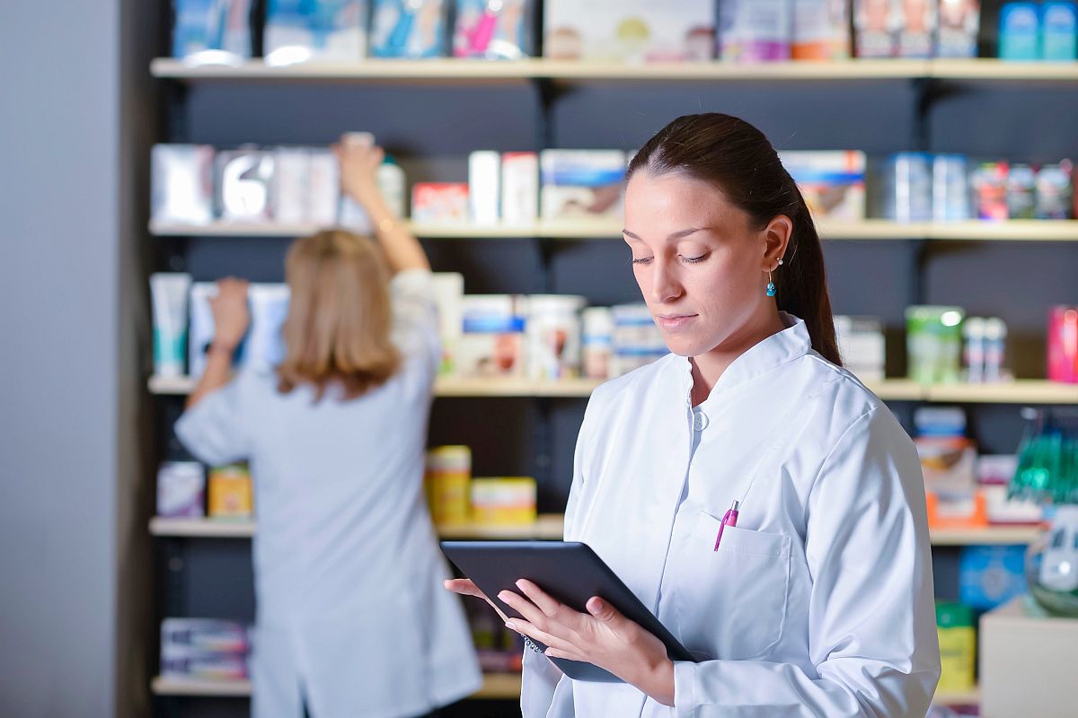 People in white lab coats working in pharmacy; payer systems concept