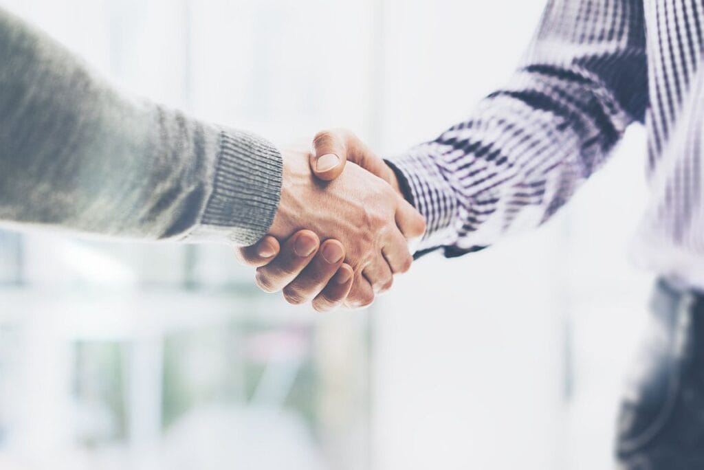 Close-up of two men shaking hands; market access strategy concept