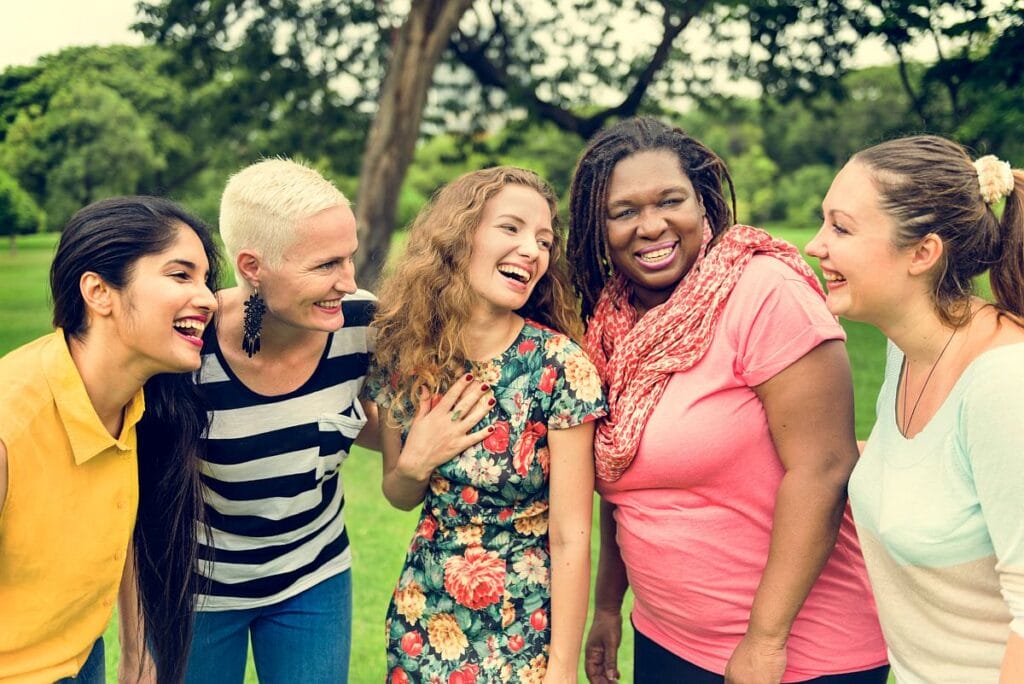 Group of women standing close together and laughing; rare disease communities concept