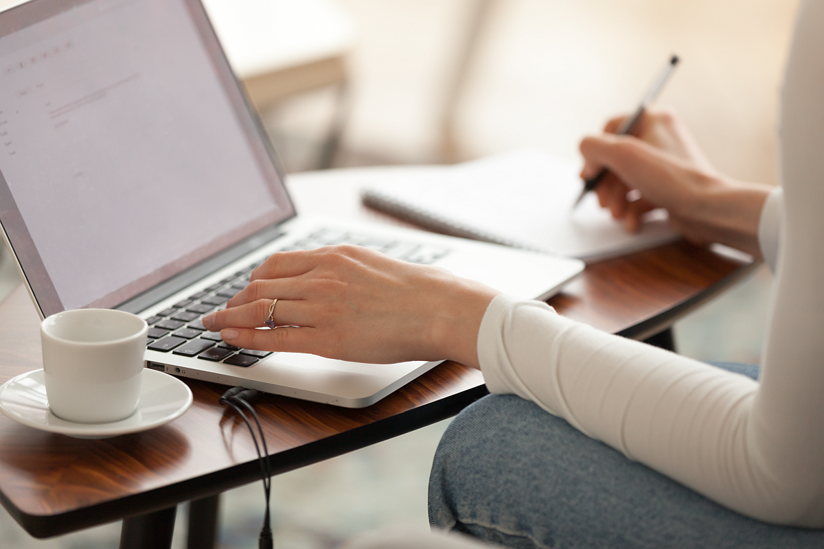 close-up of older person's hand using a laptop; prior authorization concept