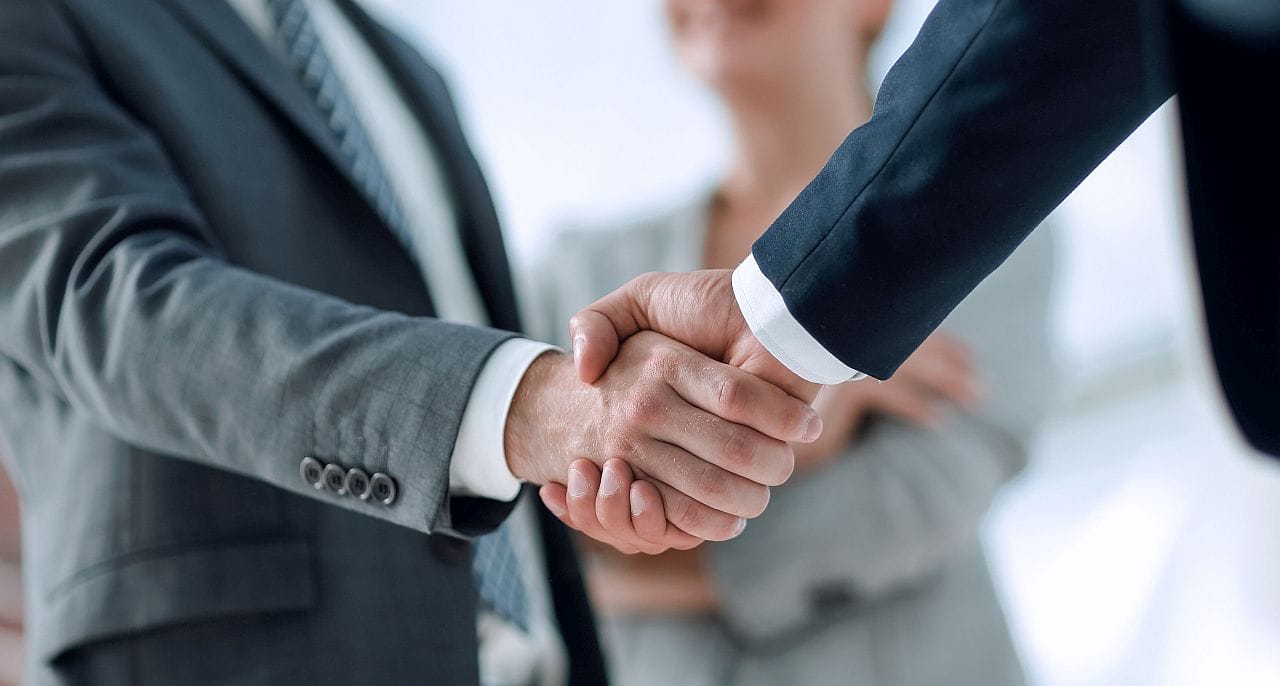 Close-up of two professionals shaking hands; value of rare disease therapies concept