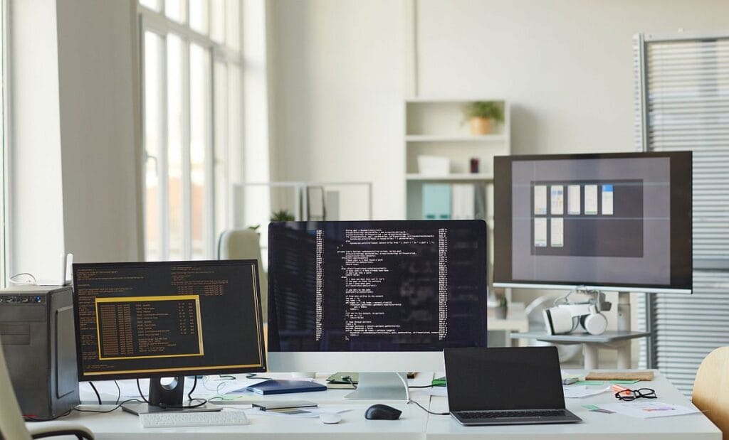 Several monitors on desk top; logistics providers’ data concept.