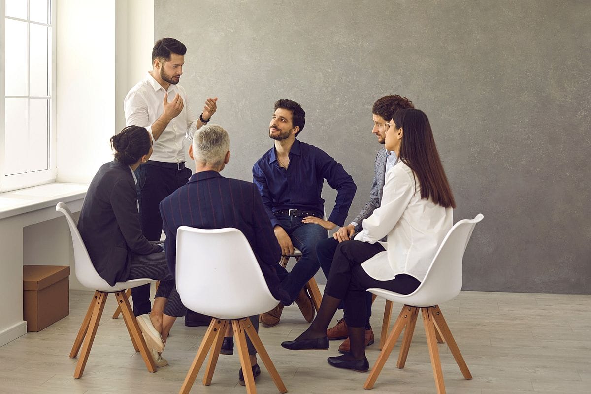 Group of professionals sitting in circle; centers of excellence concept