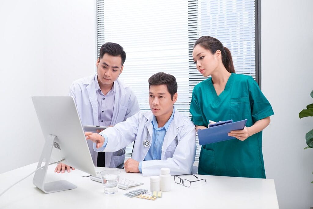 Group of healthcare professionals looking at desktop monitor; track the right data concept