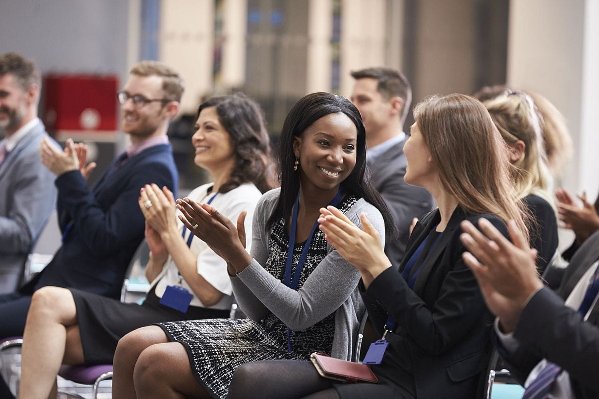 Audience applauding conference speaker; Asembia 2023 conference concept