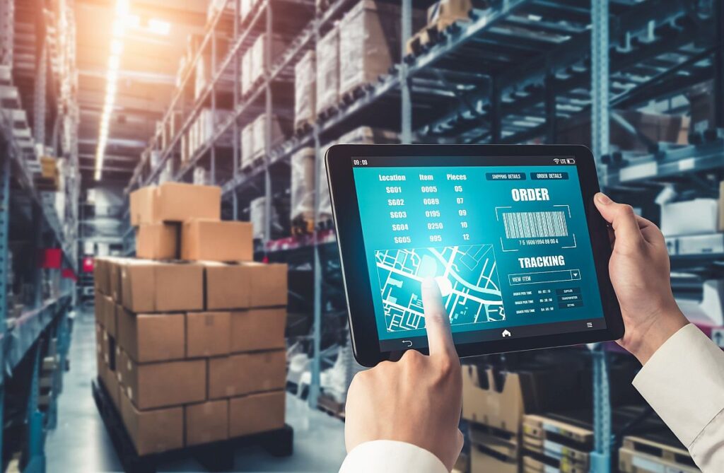 Warehouse worker using tablet to manage inventory; data-driven logistics concept