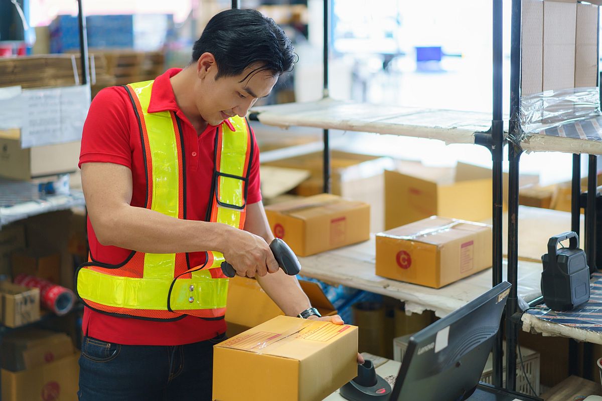 Worker scanning packages; data-driven logistics concept 
