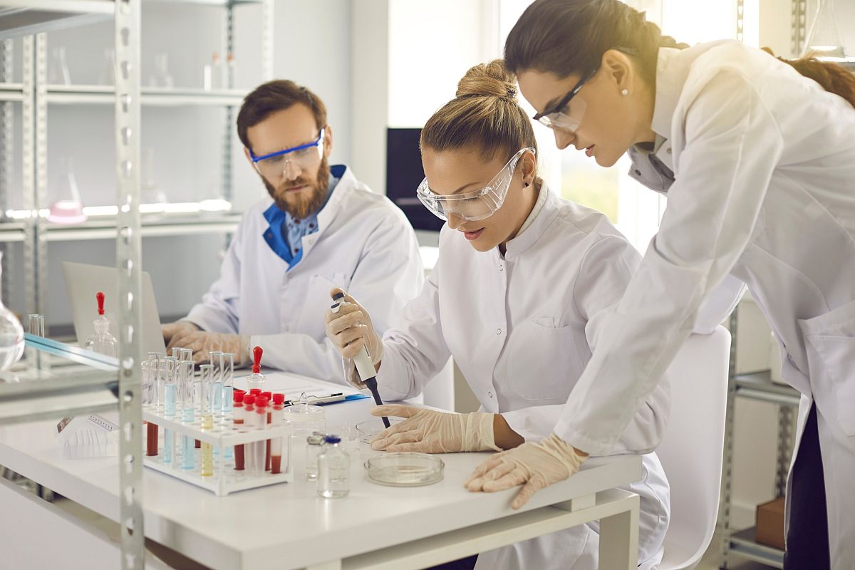 Scientists and lab technicians working together in laboratory; specialty drug market concept