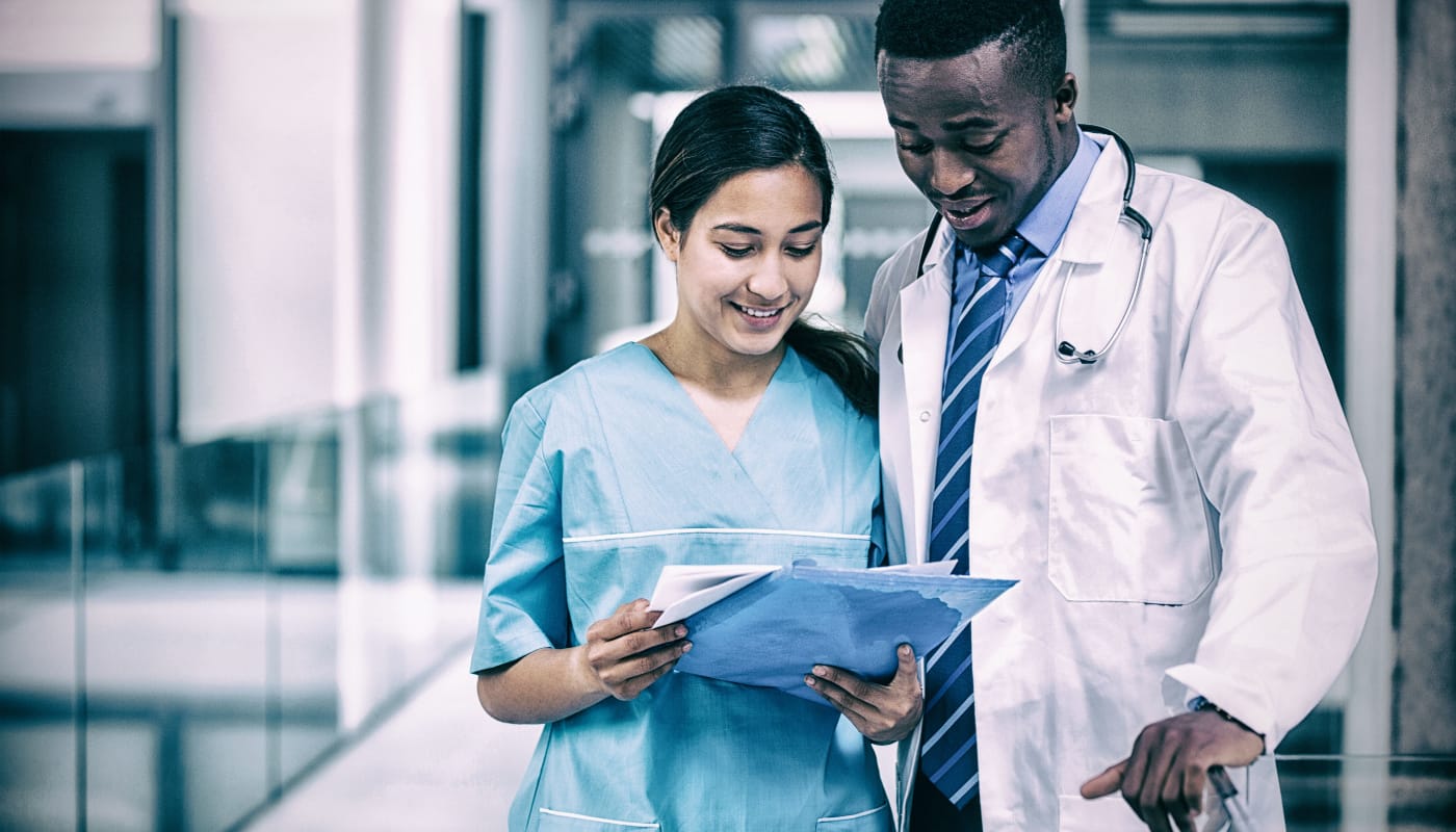 Two healthcare professionals looking at documents; shareable medical data concept