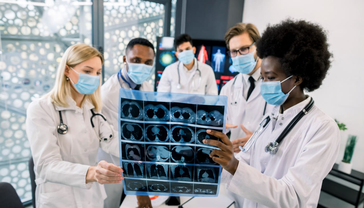 Team of doctors looking at scans together; collaborative patient management concept