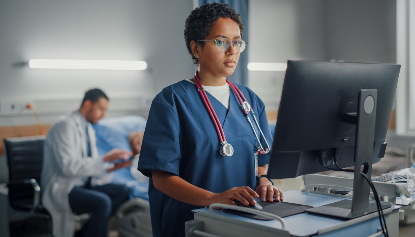 healthcare worker updating patient file on computer; Patient-Reported Outcomes concept