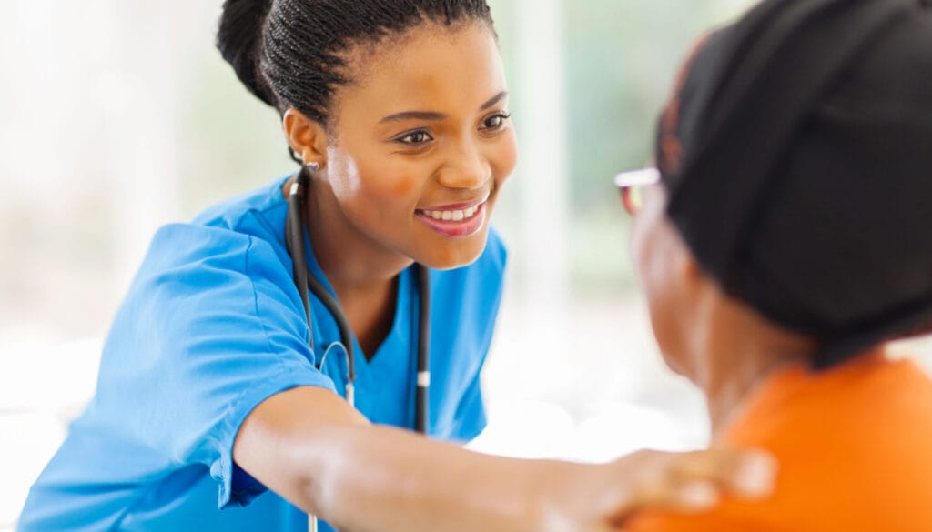 Smiling healthcare professional putting her hand on patient's shoulder; Patient-Reported Outcomes concept