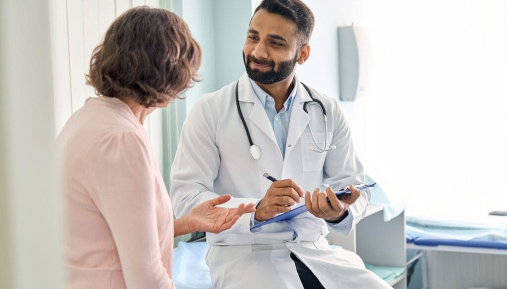 Doctor listening to patient and taking notes; Patient Services concept