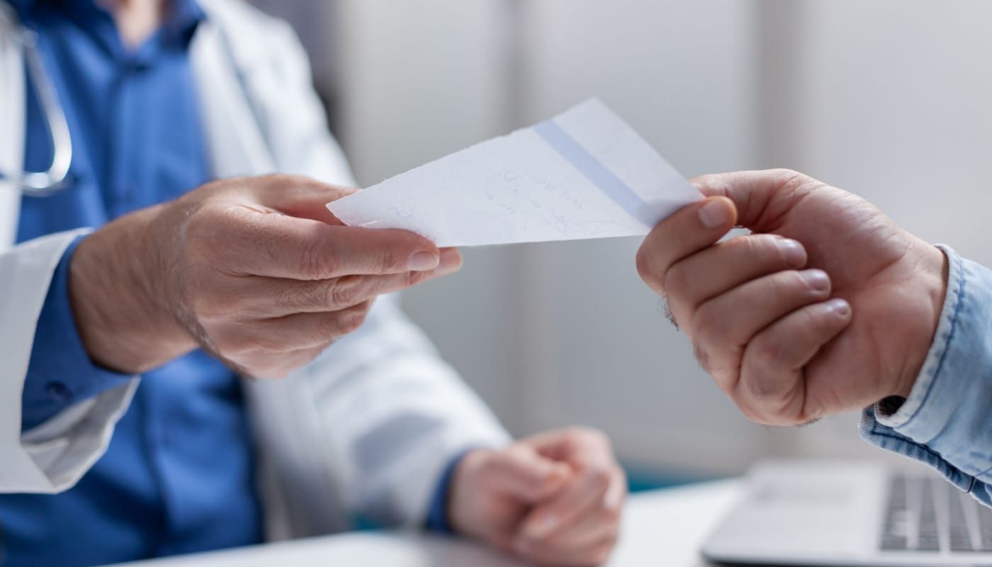 Patient handing prescription to pharmacist; biosimilars concept