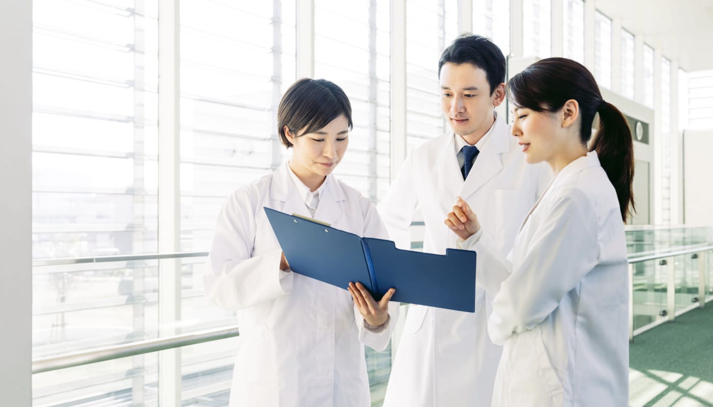 Team of healthcare professionals consulting in hallway; specialty pharmacy data concept