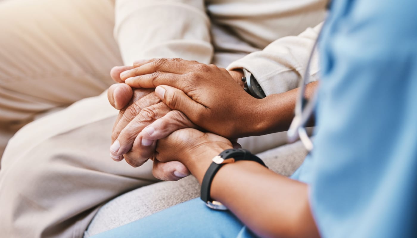 Nurse holding patient's hand; real world evidence analytics concept